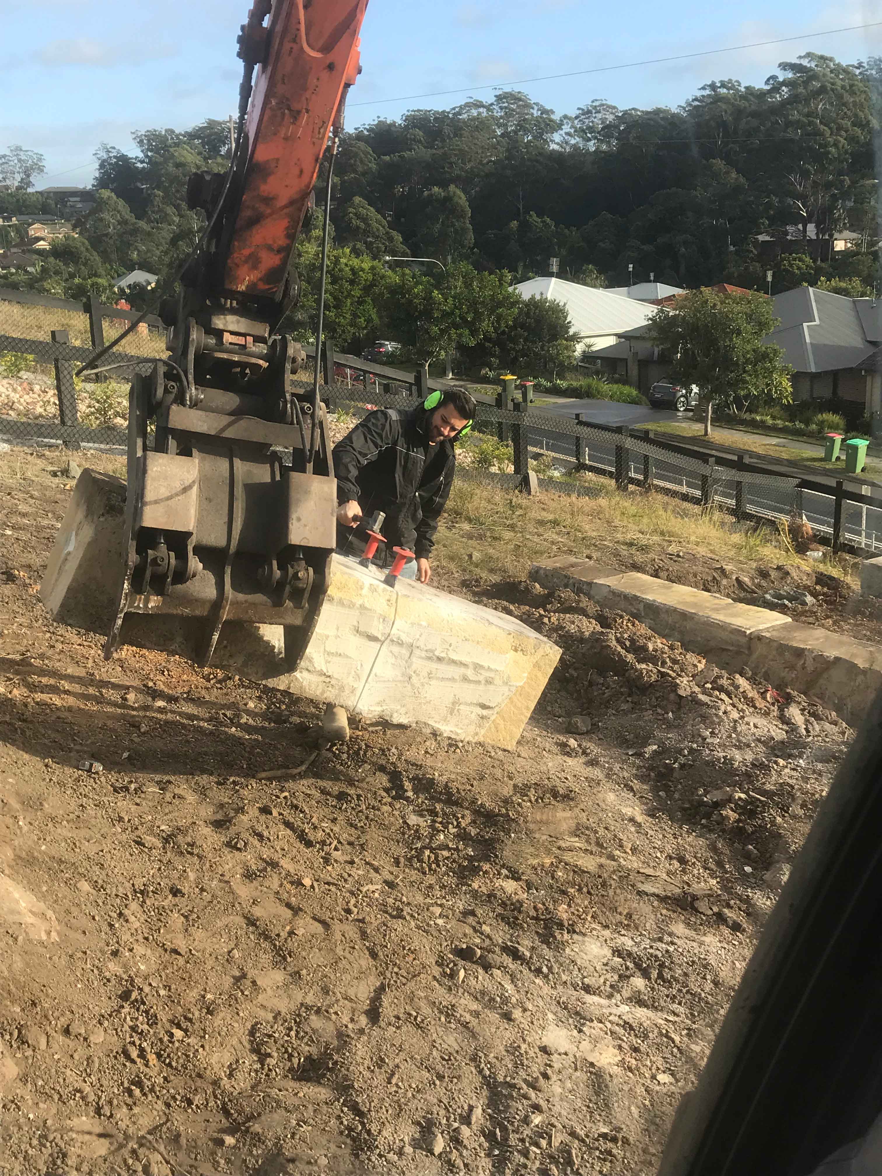 Earth mover assistance splitting sandstone blocks with hand tools